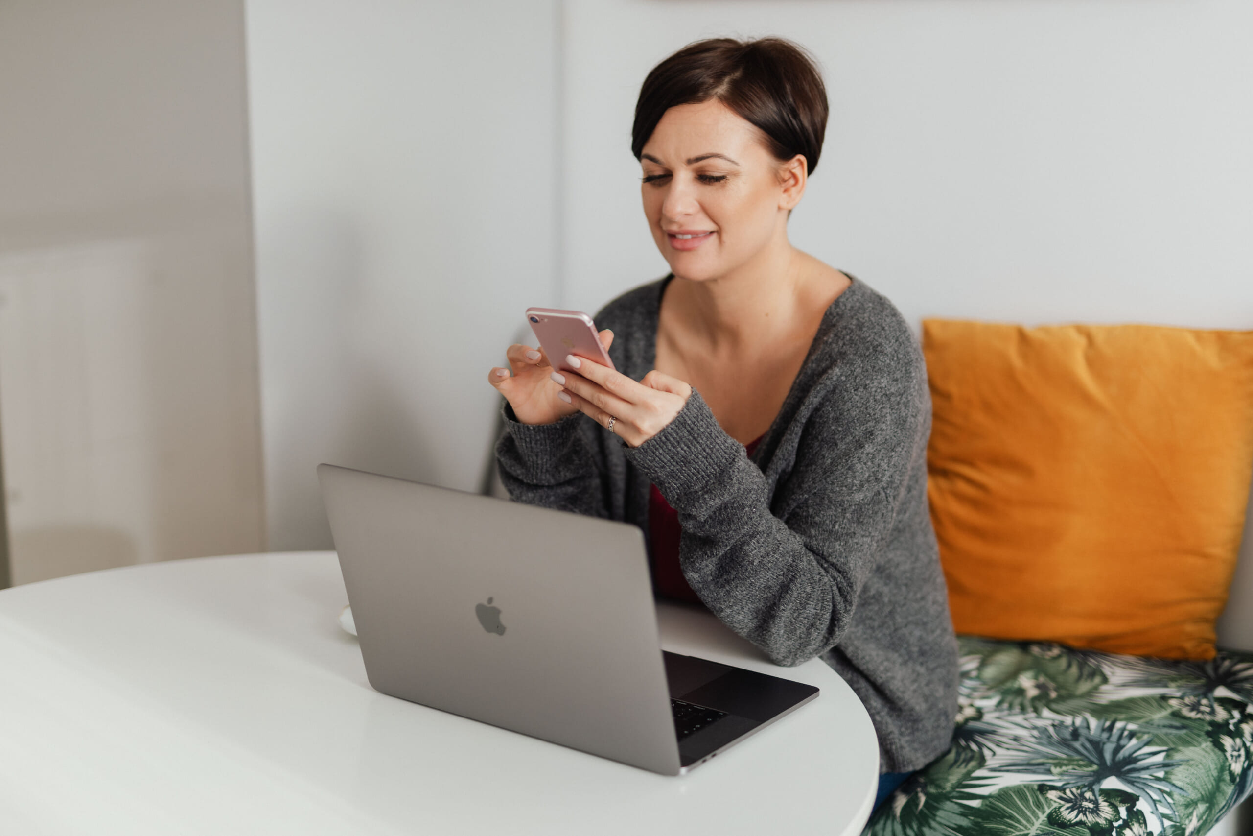 kaboompics_A brunette woman works with a laptop and a phone